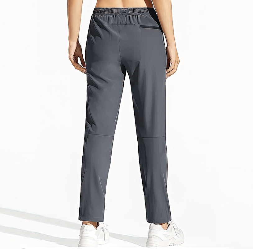 Back view of women's waterproof quick-drying hiking pants with pockets and elastic waist, ideal for outdoor adventures.